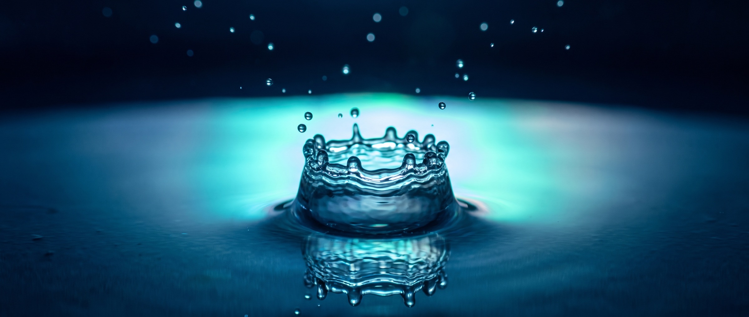 Una gota de agua cae sobre una superficie en calma y forma una corona